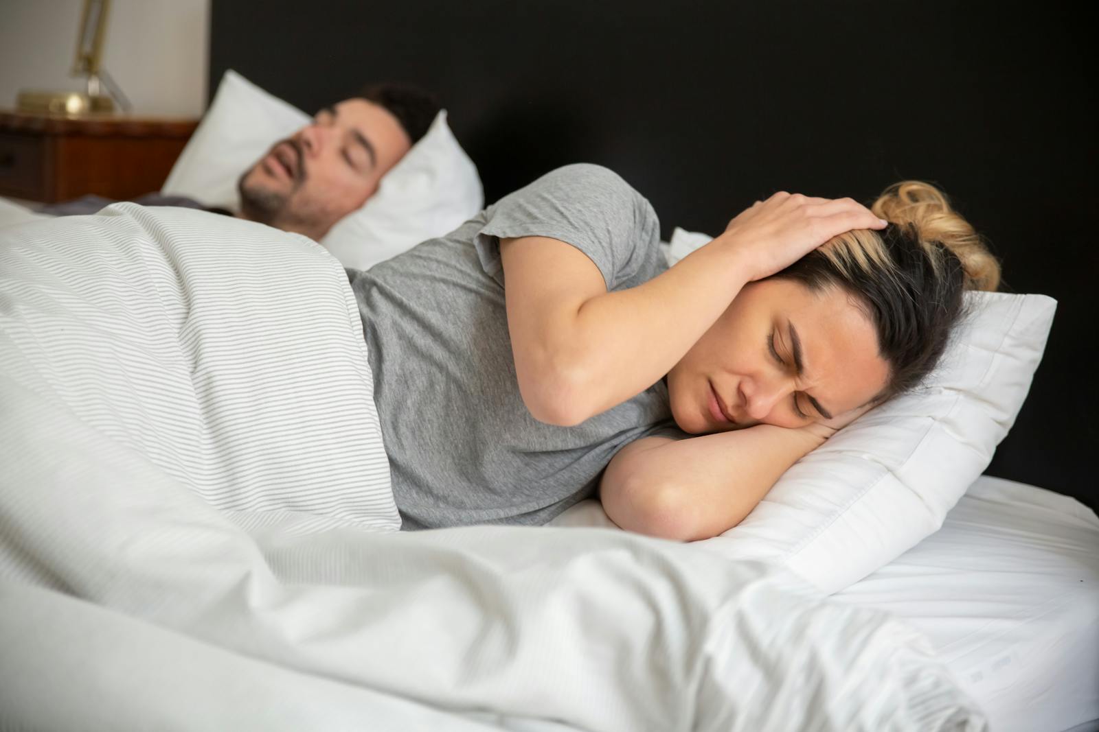 Couple au lit, une personne gênée par les ronflements de l'autre